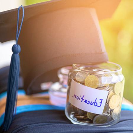 Jar labeled "Education" with graduation cap leaning against it